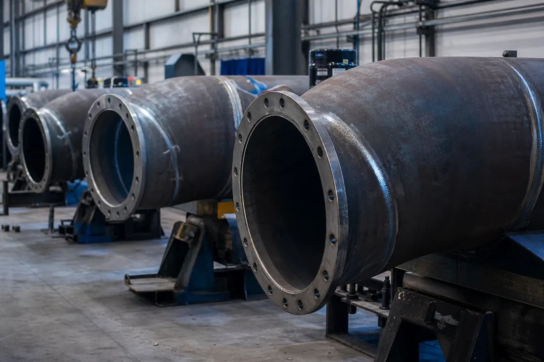 Large-diameter pipe spools with welded flanges on stands at the Telhoo workshop